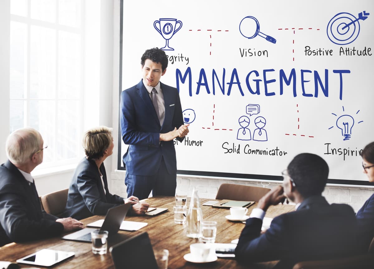 A manager leading a team and pointing at a growth chart.